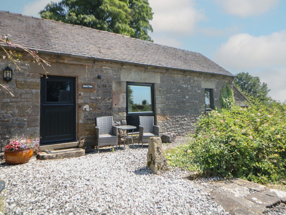 An outdoor area with chairs and table at Slade Tops in Ilam