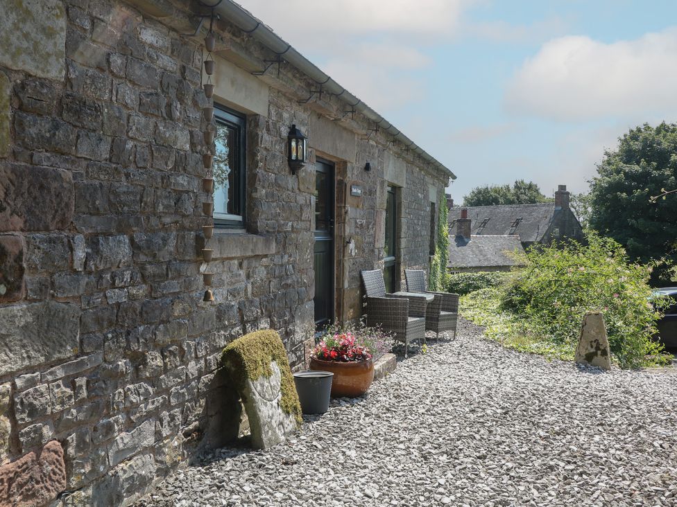 An outdoor area with stone walls and seating at Slade Tops in Ilam