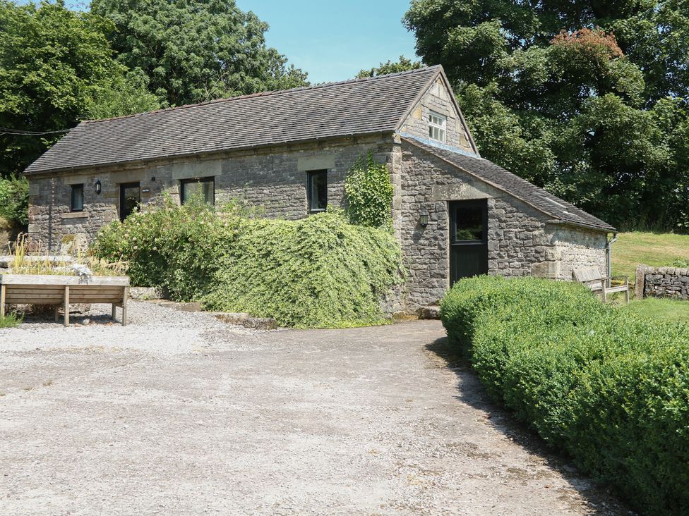 A stone building with greenery and a path at Slade Tops in Ilam