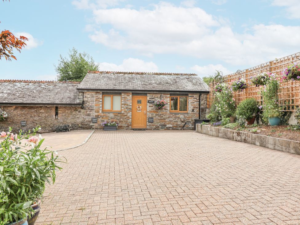 An outdoor area with a stone building and flower pots at Whitsand in Tideford