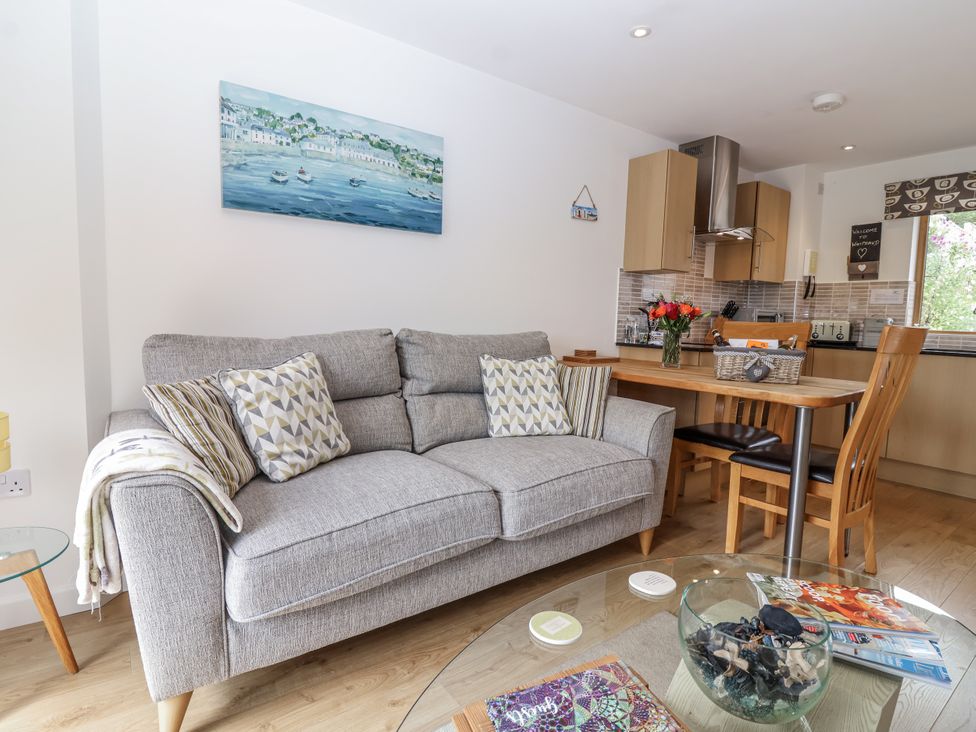 A living room with a sofa and dining table at Whitsand in Tideford