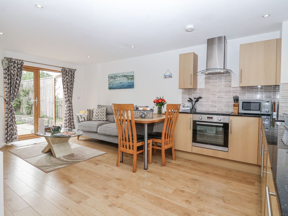 A kitchen with a dining table and sofa at Whitsand in Tideford