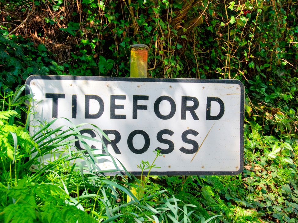 A sign that says Tideford Cross in a green setting at Whitsand in Tideford