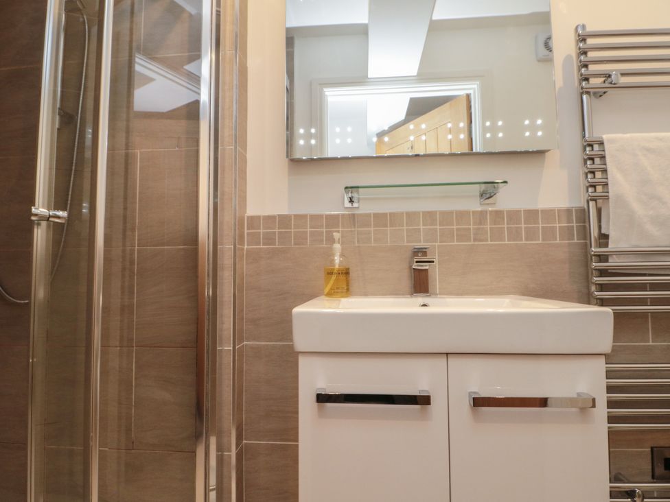 A bathroom featuring a shower, sink, and towel rail at Sir Nigel Gresley @ Engine Shed in Whitby