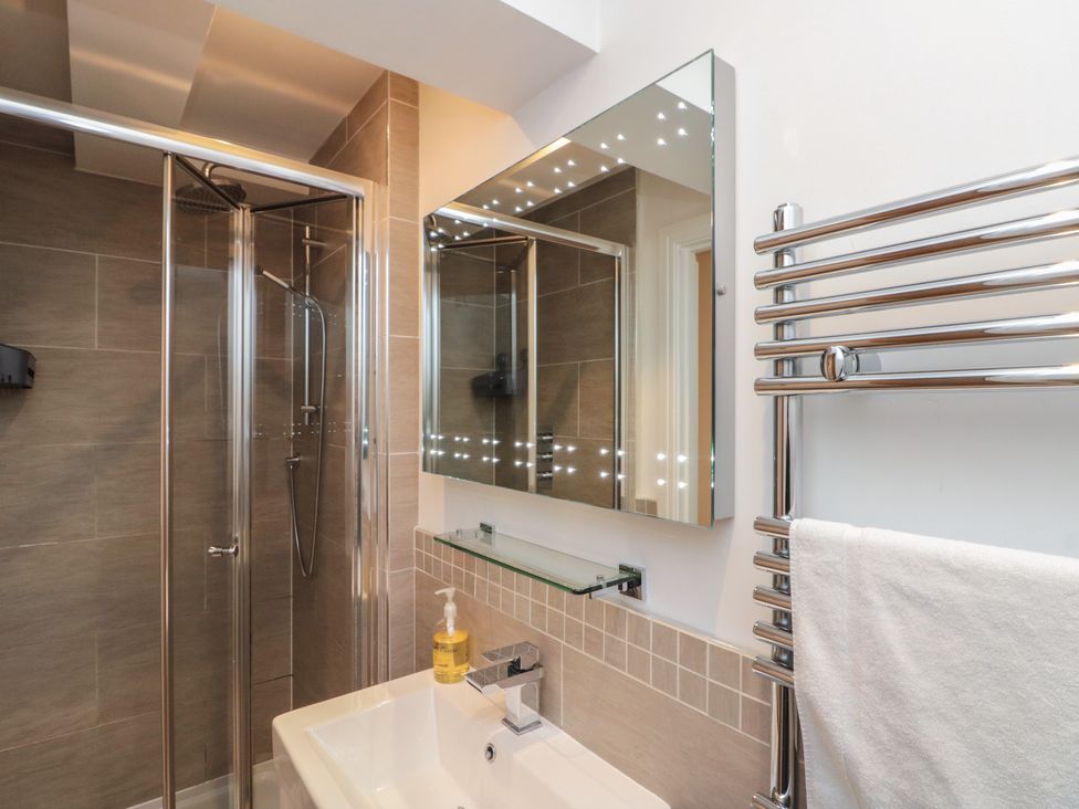 A bathroom with a shower, sink and mirror at Sir Nigel Gresley @ Engine Shed in Whitby
