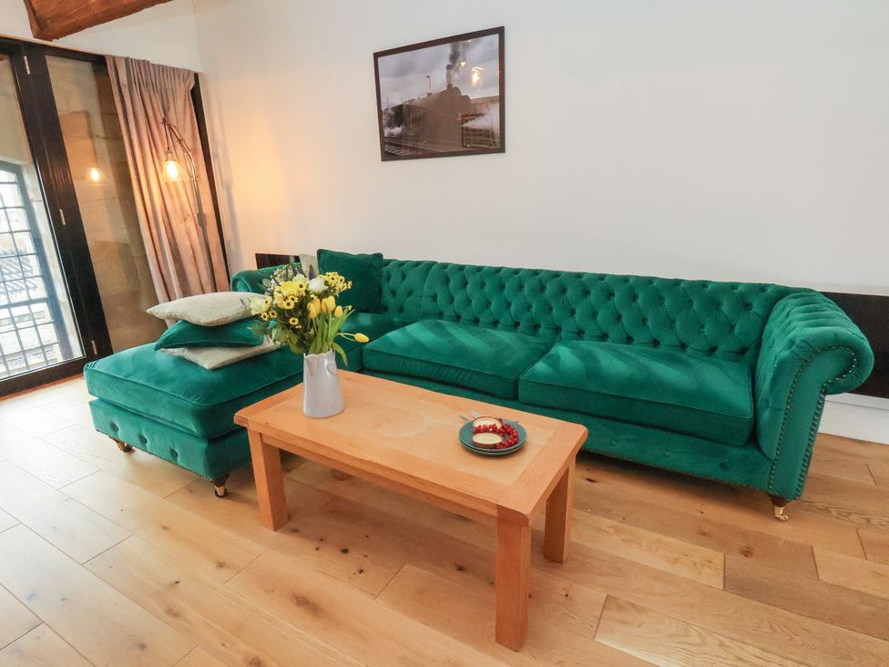 A living room with a green sofa and coffee table at Repton @ Engine Shed Whitby