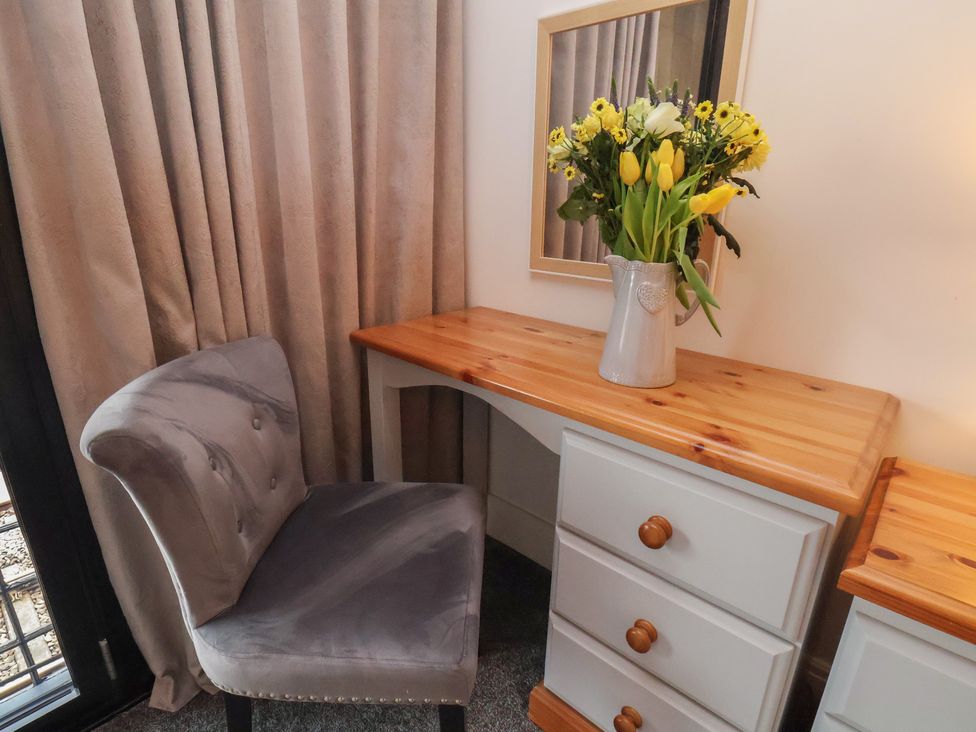 A desk with a chair and flowers at Repton @ Engine Shed in Whitby