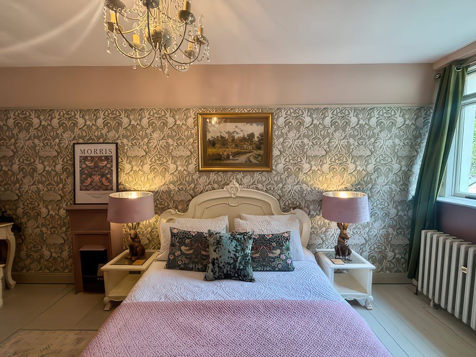 A bedroom with a bed, lamps, and a window at Liberty House in Ashbourne