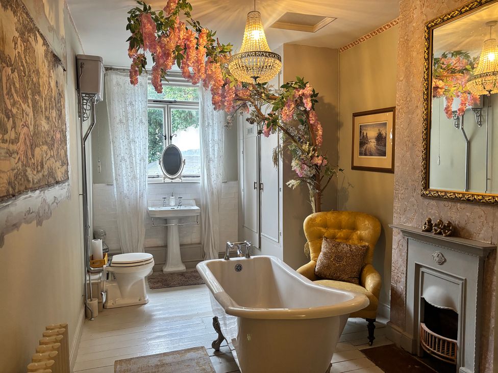 A bathroom with a bathtub and wash basin at Liberty House in Ashbourne