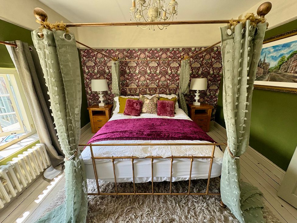 A bedroom with a four-poster bed and bedside tables at Liberty House in Ashbourne