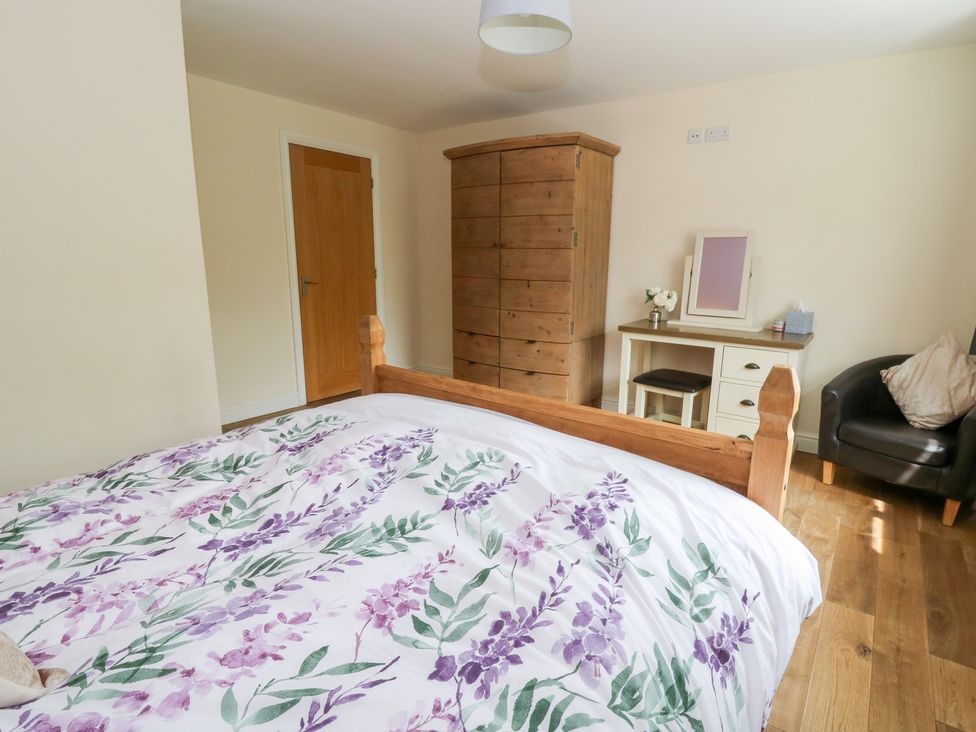 A bedroom with a bed and wardrobe at New Peny in Llandrindod Wells