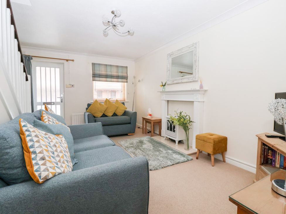 A living room with seating and a fireplace at 17 Fewster Way in York