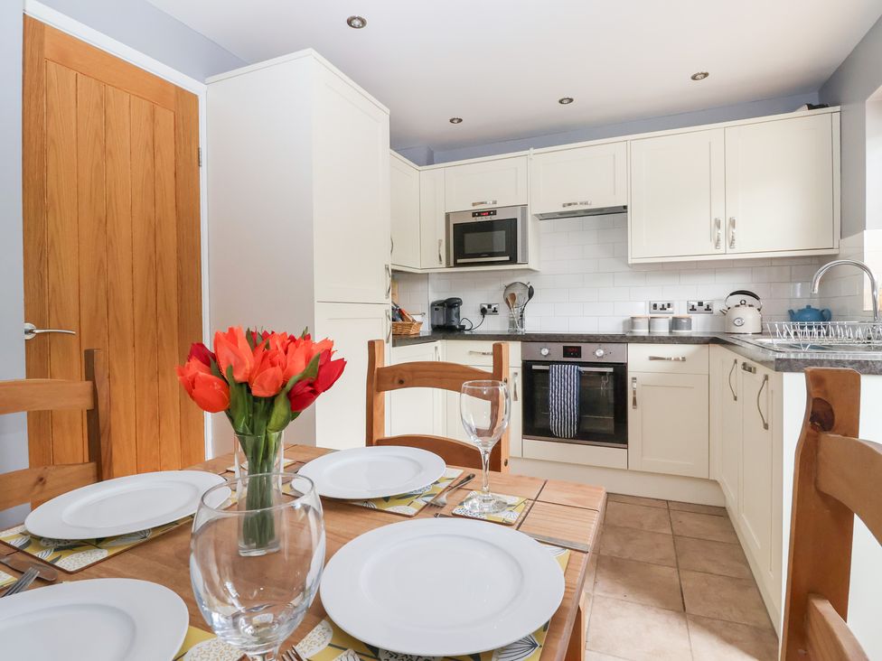 A kitchen with a dining table and flower vase at 17 Fewster Way in York