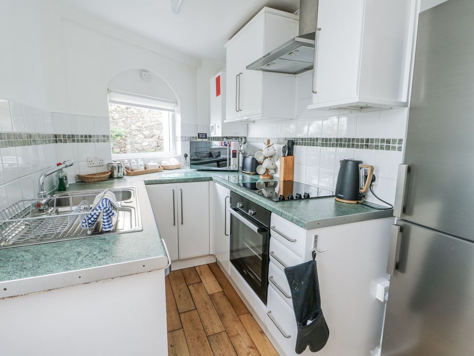 A kitchen with a sink, oven, and various appliances at Preswylfa Apartment in Caernarfon