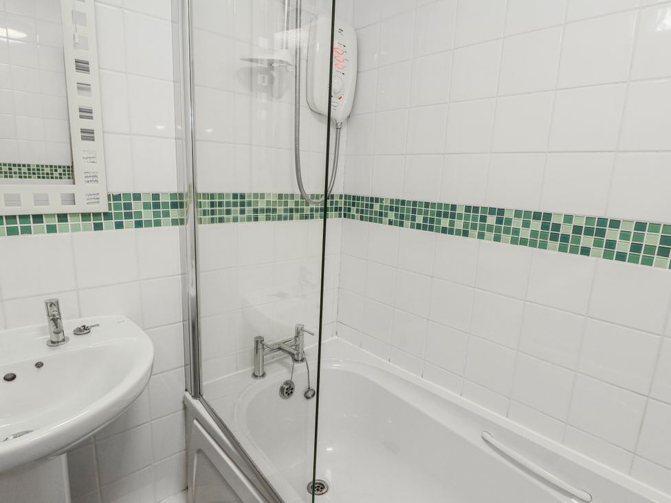 A bathroom with a shower and bathtub at Preswylfa Apartment Caernarfon