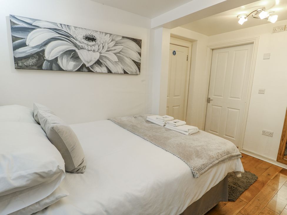 A bedroom with a bed and towels at Preswylfa Apartment Caernarfon