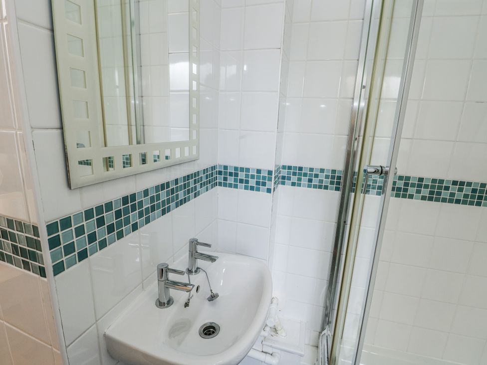 A bathroom with a sink and shower at Preswylfa Apartment in Caernarfon