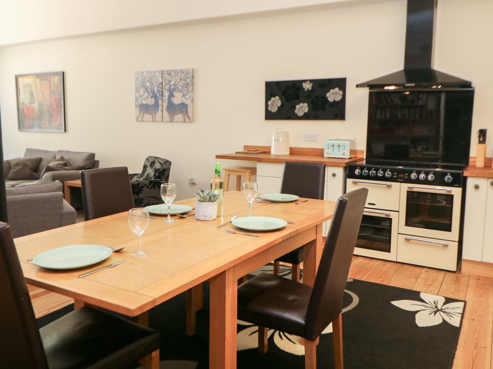 A kitchen with a dining table set and appliances at Wye Apartment, Litton Mill