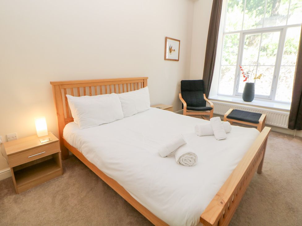 A bedroom with a bed and chair at Wye Apartment, Litton Mill in Litton Mill