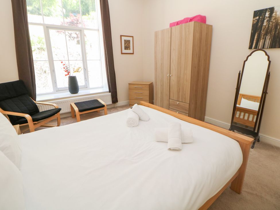 A bedroom with a bed and chair at Wye Apartment, Litton Mill in Litton Mill