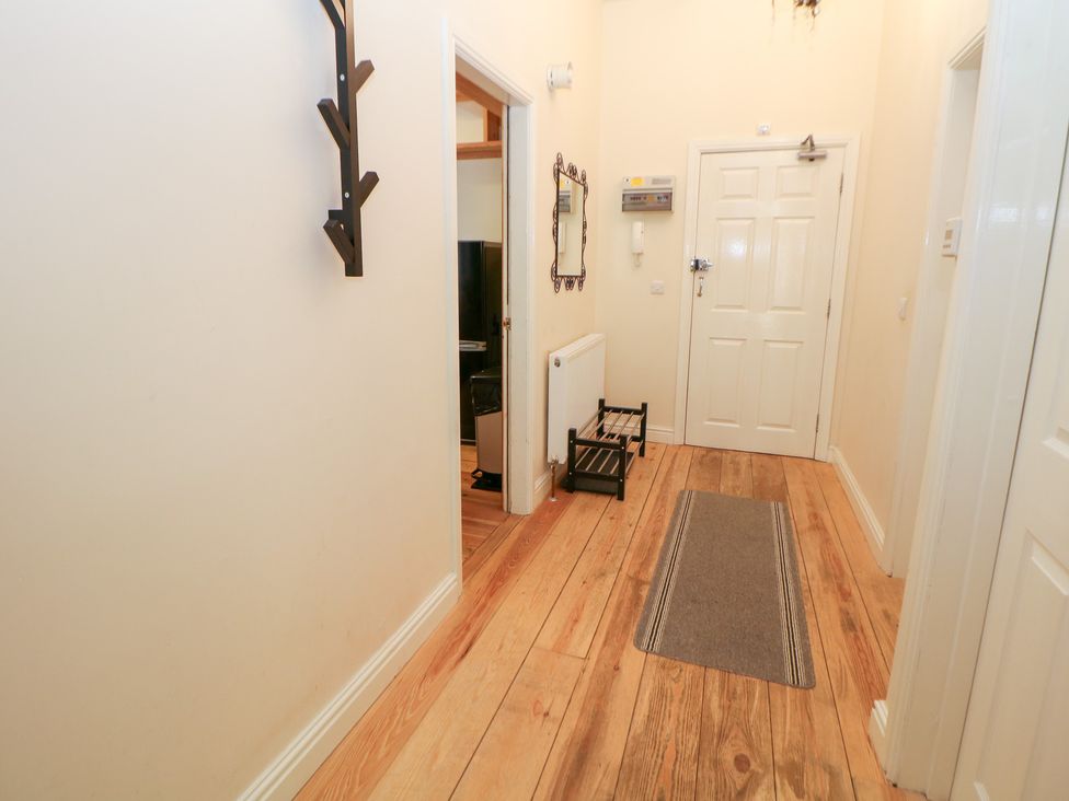 A hallway with a mirror, coat rack, and radiator at Wye Apartment, Litton Mill