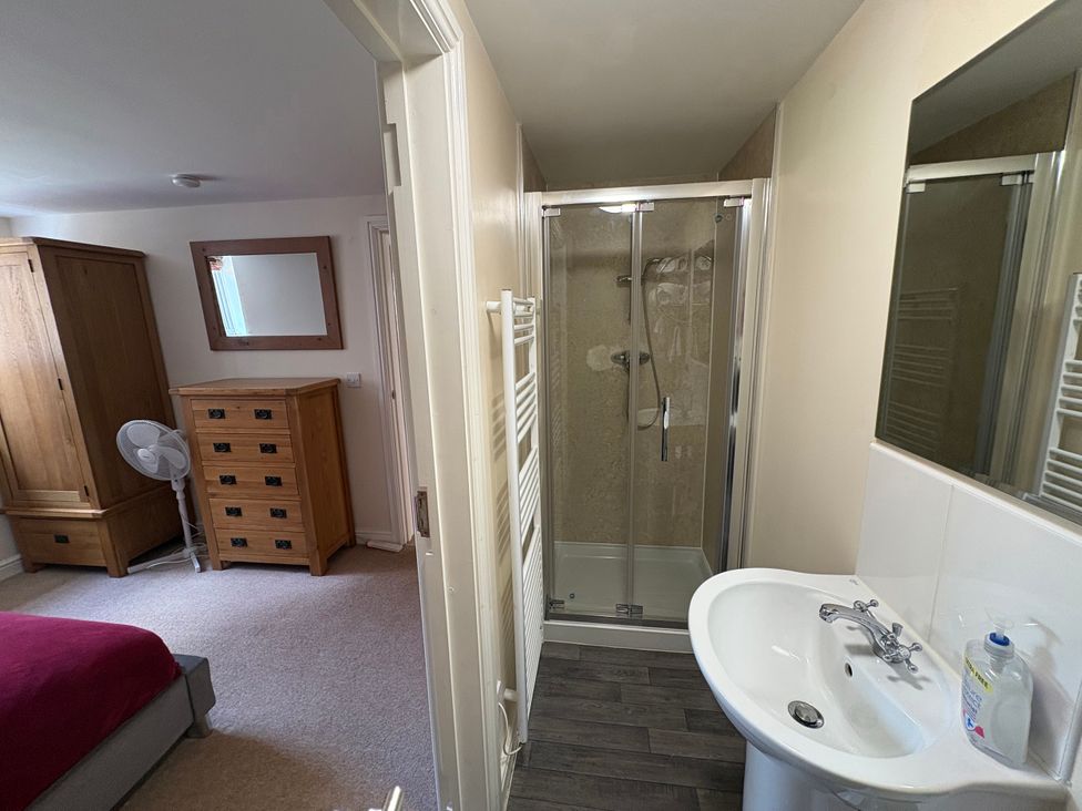 A bathroom with a shower and washbasin at The Joiners Shop in Melbourne, Derbyshire