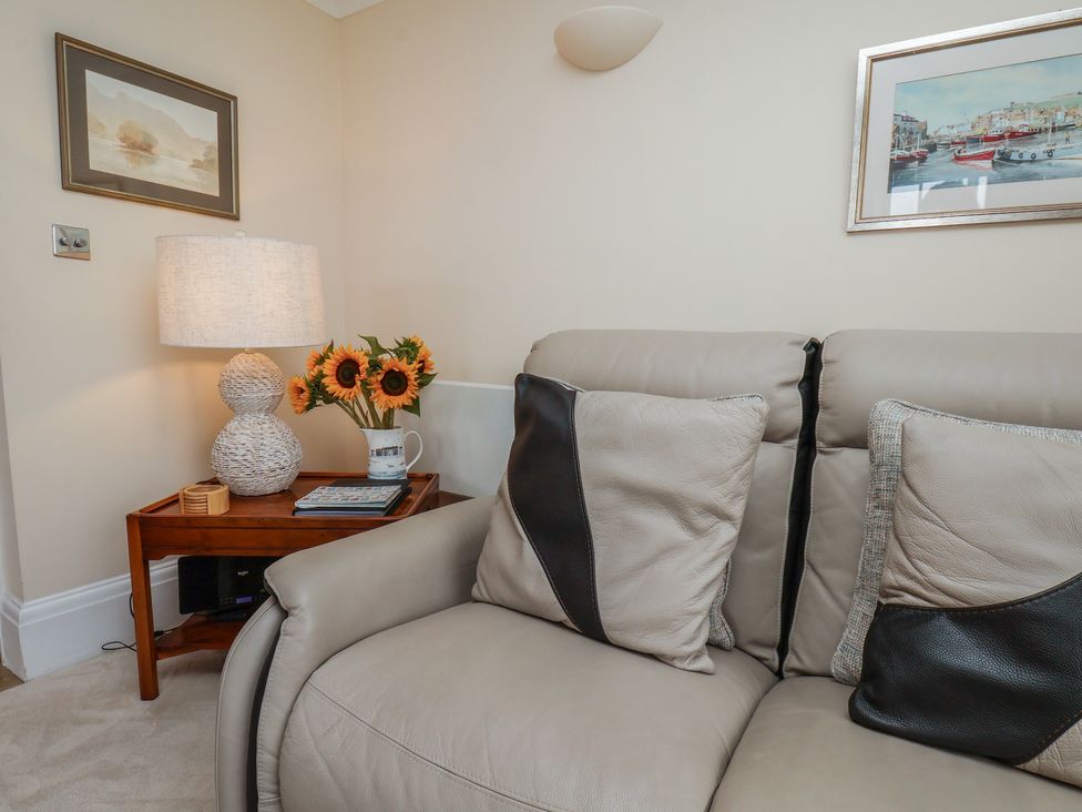 A living room with a sofa and decorative items at 5 Old Sail Loft in Whitby