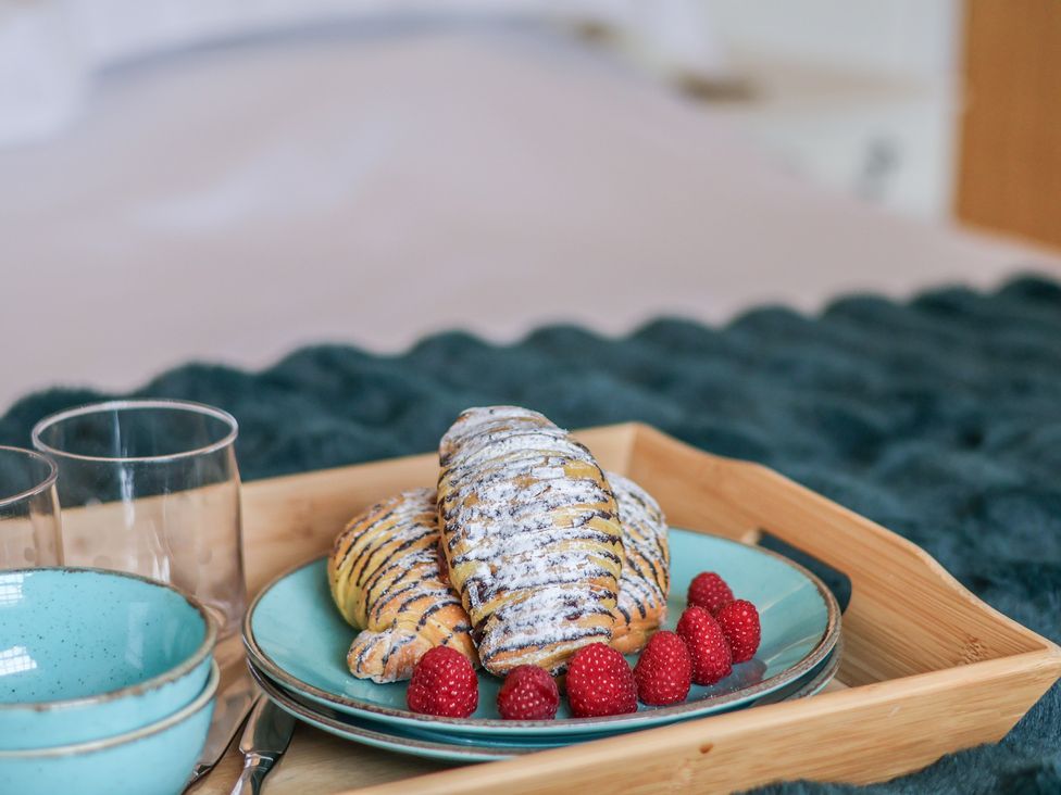 A tray with croissants and raspberries in a bedroom at 5 Old Sail Loft Whitby