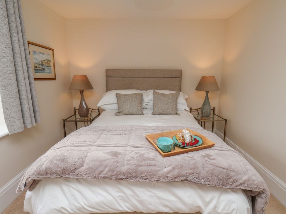 A bedroom with a bed and nightstands at 5 Old Sail Loft in Whitby